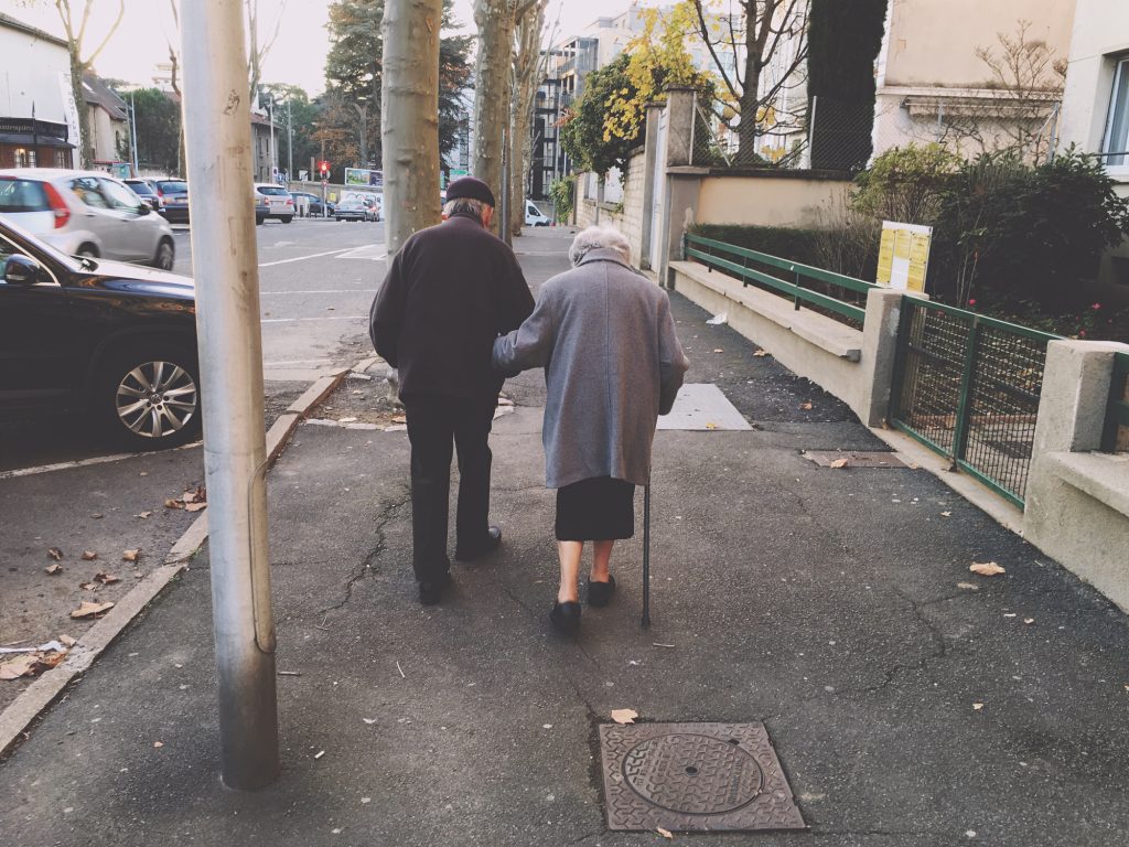 Rear View Of Senior Couple Walking On Street